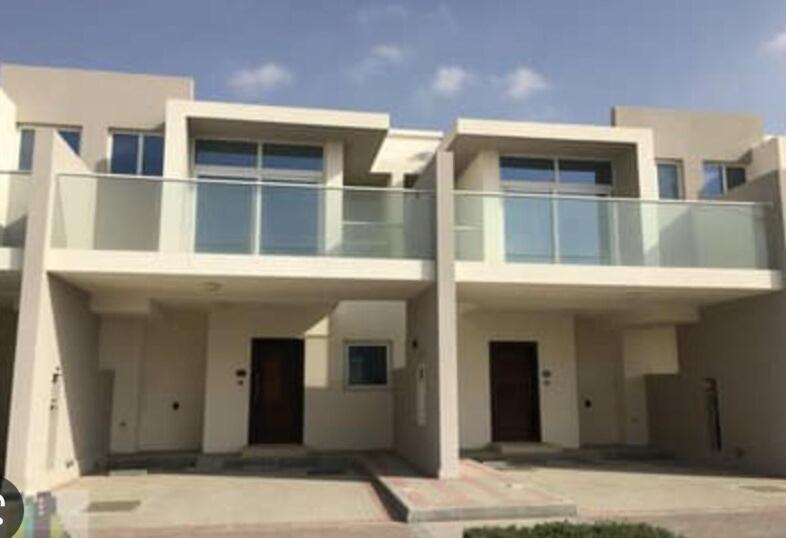 a large white building with a balcony on it at Damac Hills 2- Relaxing 3BR townhouse - Homeyvillas in Dubai