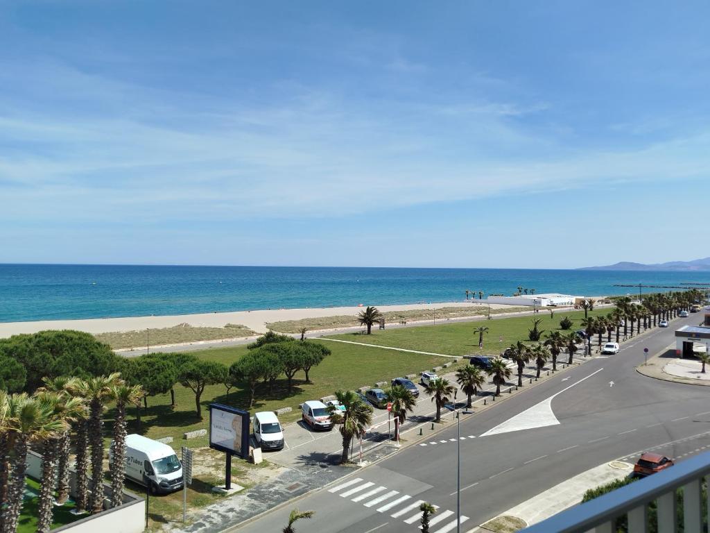 une rue avec des voitures garées sur une route à côté de la plage dans l'établissement Superbe T2 refait à neuf à 2 pas de la plage - 5FL87, à Saint Cyprien Plage