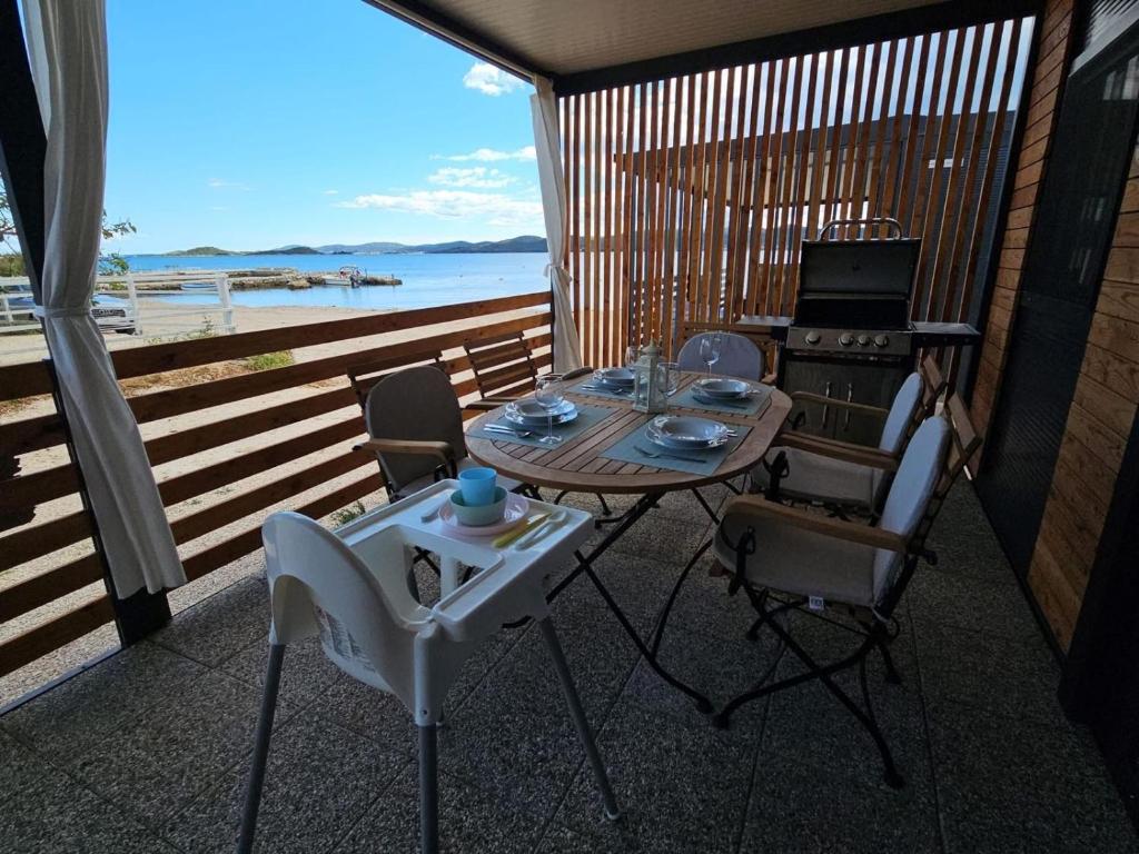 a table and chairs on a balcony with a view of the ocean at Rock Mobile Home in Sveti Petar