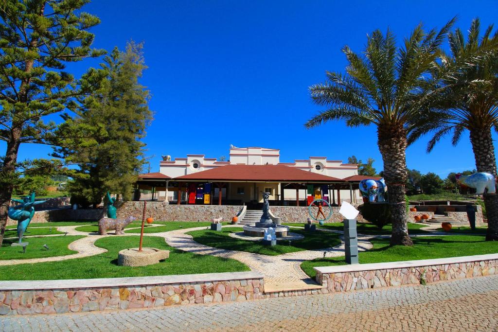 um parque com palmeiras e um edifício em Quinta dos Vales Wine Estate em Estômbar