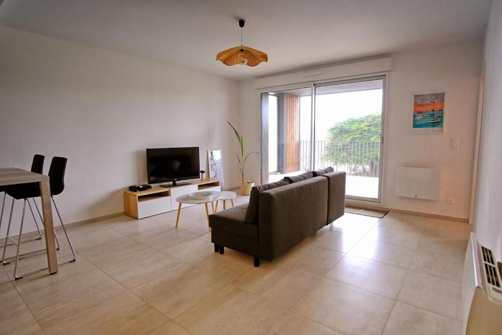 un salon avec un canapé et une télévision dans l'établissement T2 neuf haut standing Pornichet proche mer, à Pornichet