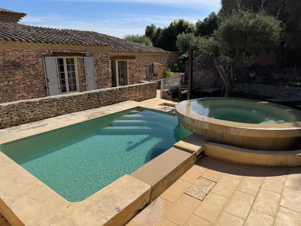 a swimming pool with a fountain in front of a house at Villa Lavezzi avec piscine in Bonifacio
