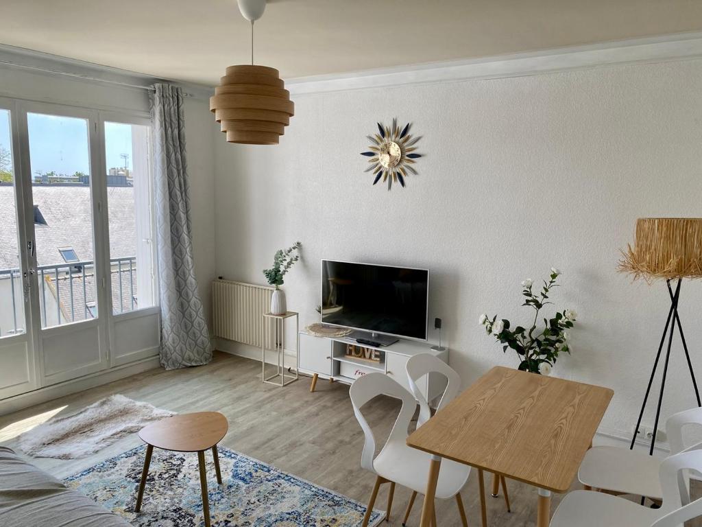 un salon avec une table et une télévision dans l'établissement L'Escale Colombe, Appartement à Concarneau, à Concarneau
