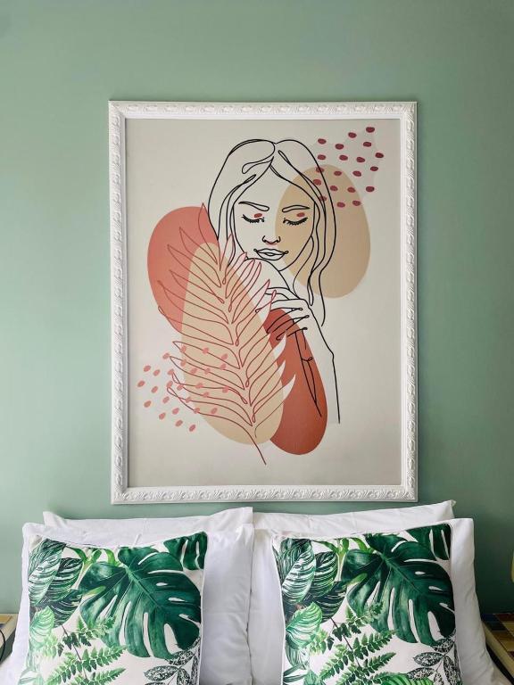 a picture of a woman with a feather above a bed at 361 On Sunset in Sandton