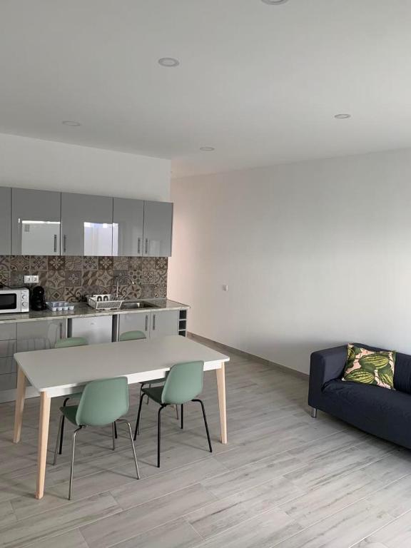 a kitchen with a table and chairs and a couch at Casa Jonhy in Faro