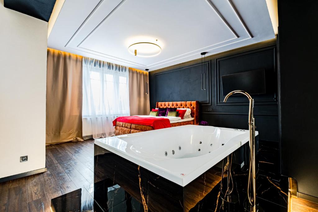 a bathroom with a tub and a bed in a room at Merido Apartment in Nitra