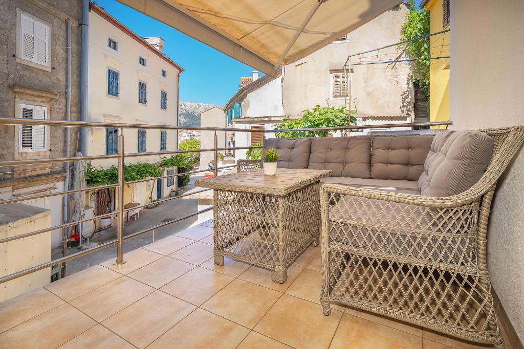 Appartamento dotato di balcone con divano e tavolo. di Apartment Porto with Terrace a Baška