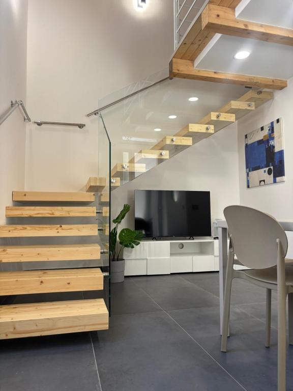 a staircase in a room with a table and a television at Cortiletto Pavone A in Catania