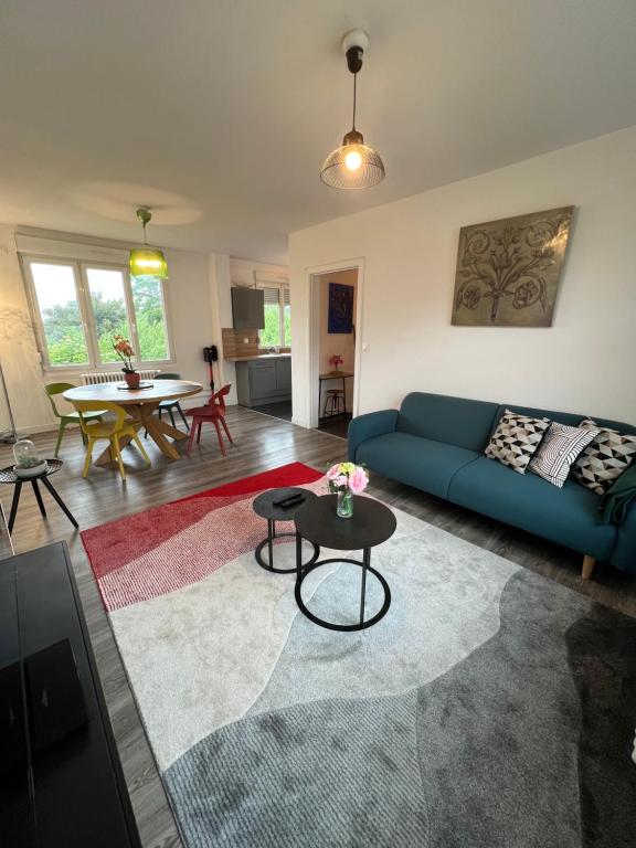 a living room with a blue couch and a table at « stef one « centre ville 2 chambres 3 voyageurs in Valenciennes