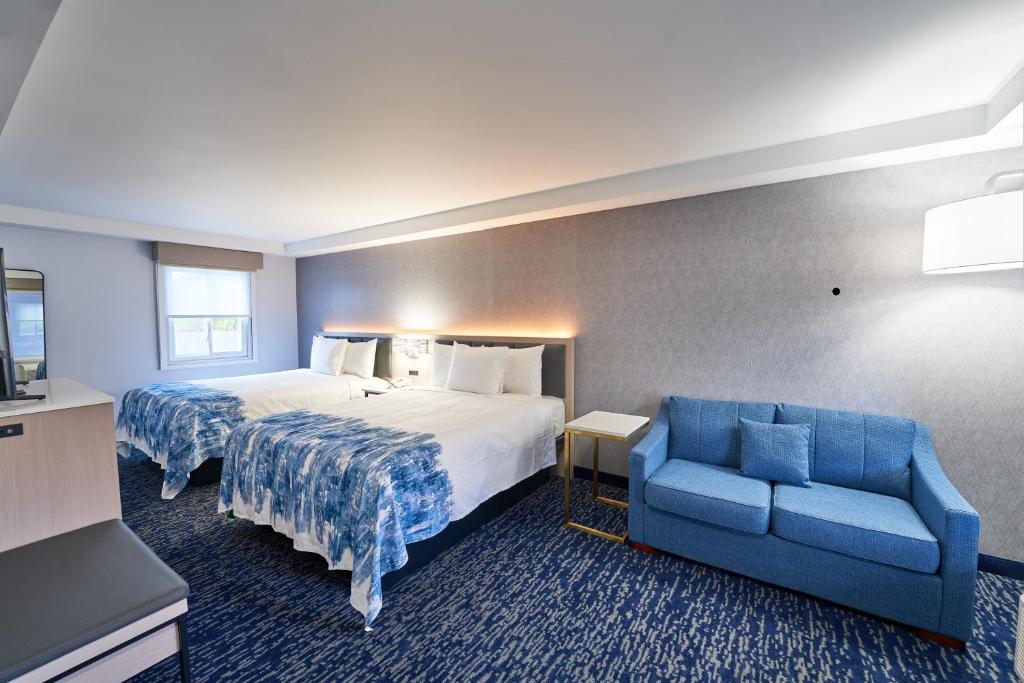 a hotel room with a bed and a blue couch at The Bridgeway in Bourne