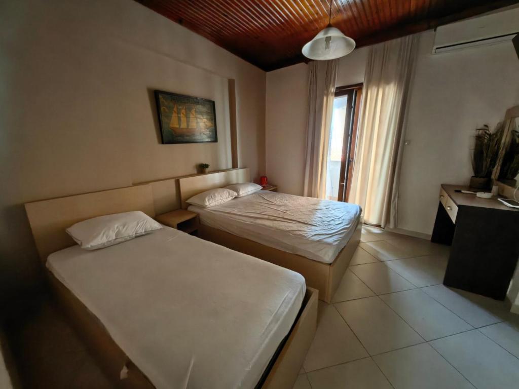 una camera d'albergo con due letti e una finestra di Blue Levantes a Pefkohori