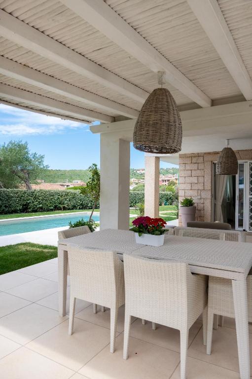 an outdoor dining area with a white table and chairs at Summer Luxury Apartment Adults Only in Olbia