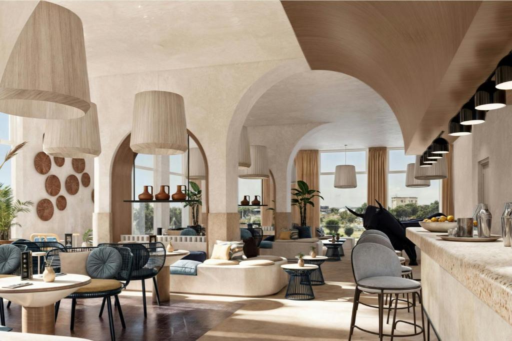 a lobby with chairs and tables and a bar at Cala Ponte, a Tribute Portfolio Hotel in Polignano a Mare