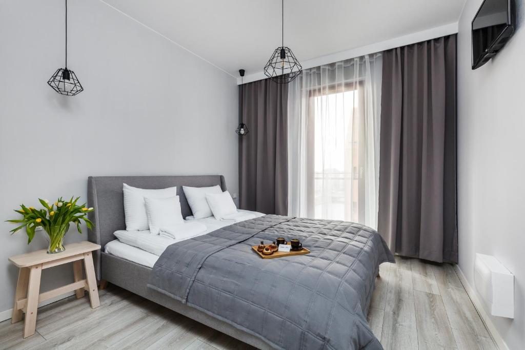 a bedroom with a bed with a tray of food on it at Nowa Motława Residence by HappyStay in Gdańsk
