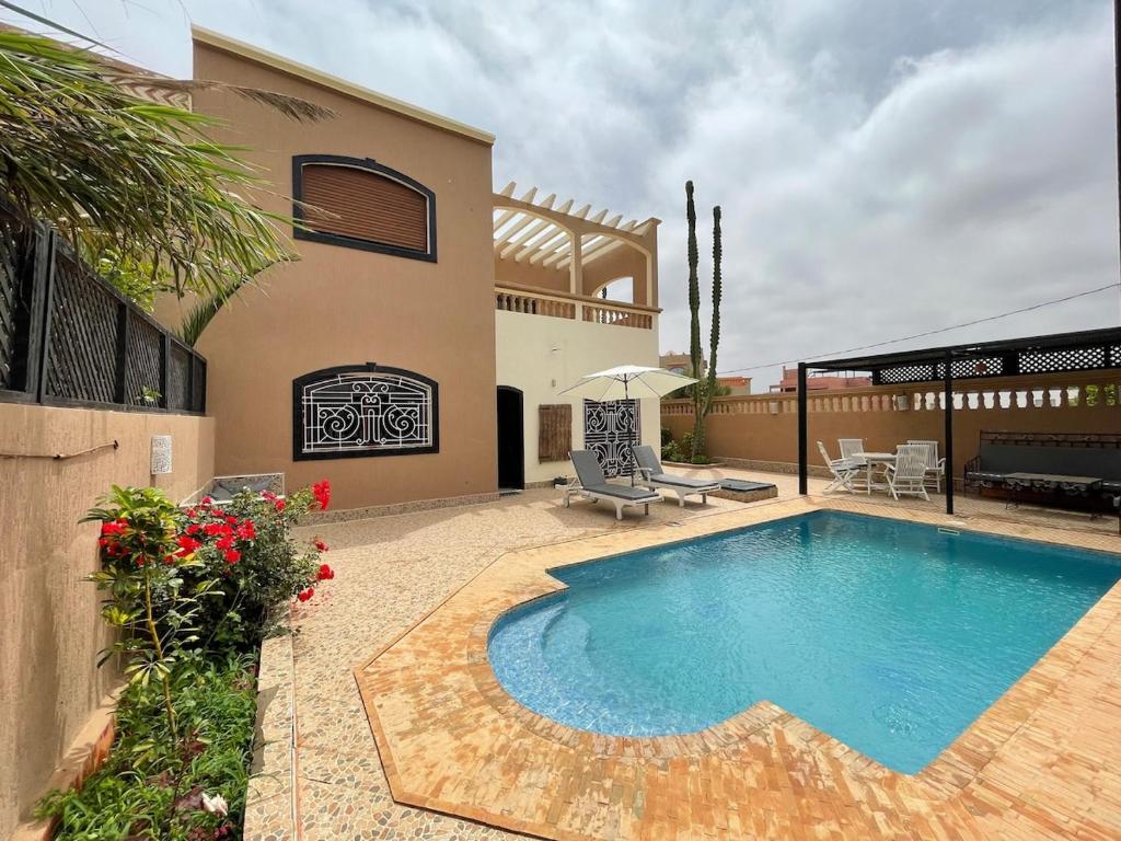 a swimming pool in front of a house at Modern villa with pool in Mirleft