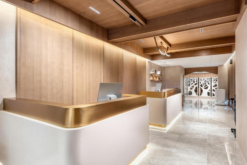 広州市にあるDingshe Hotel Guangzhou Shamian Island Yongqingfang Branchの金色のカウンターと机のあるロビー