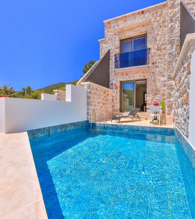 a villa with a swimming pool in front of a house at Nouba Villas in Kaş