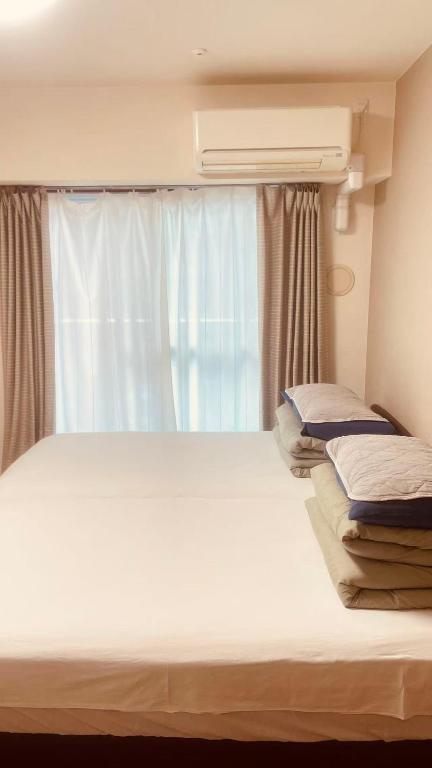 Postel nebo postele na pokoji v ubytování SkyHotel Ryogoku 駅徒歩4分