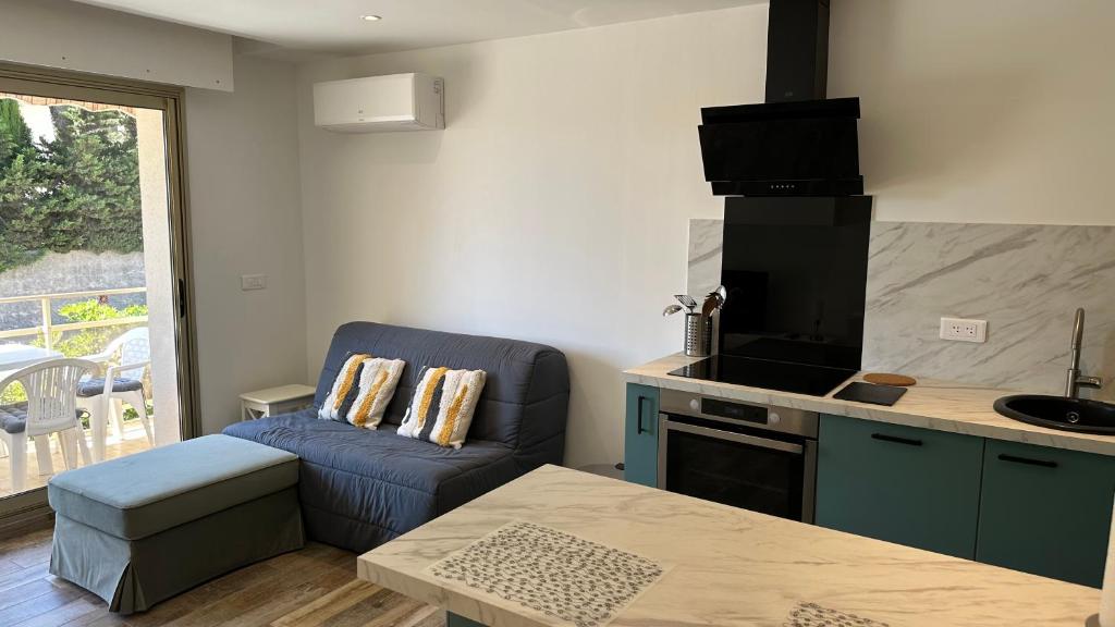 - une cuisine avec un canapé et une table dans une chambre dans l'établissement Appartement Neuf - Six Fours Les plages - Parking privatif - Clim - Balcon - 500m de la mer, à Six-Fours-les-Plages