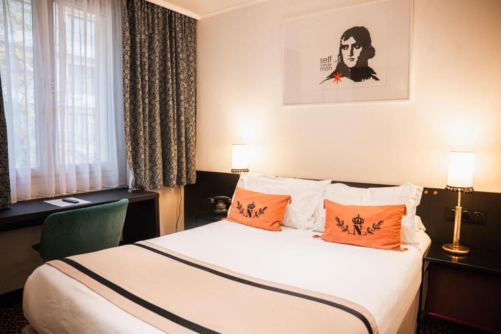 a hotel room with a bed with orange pillows at Napoleon in Ajaccio