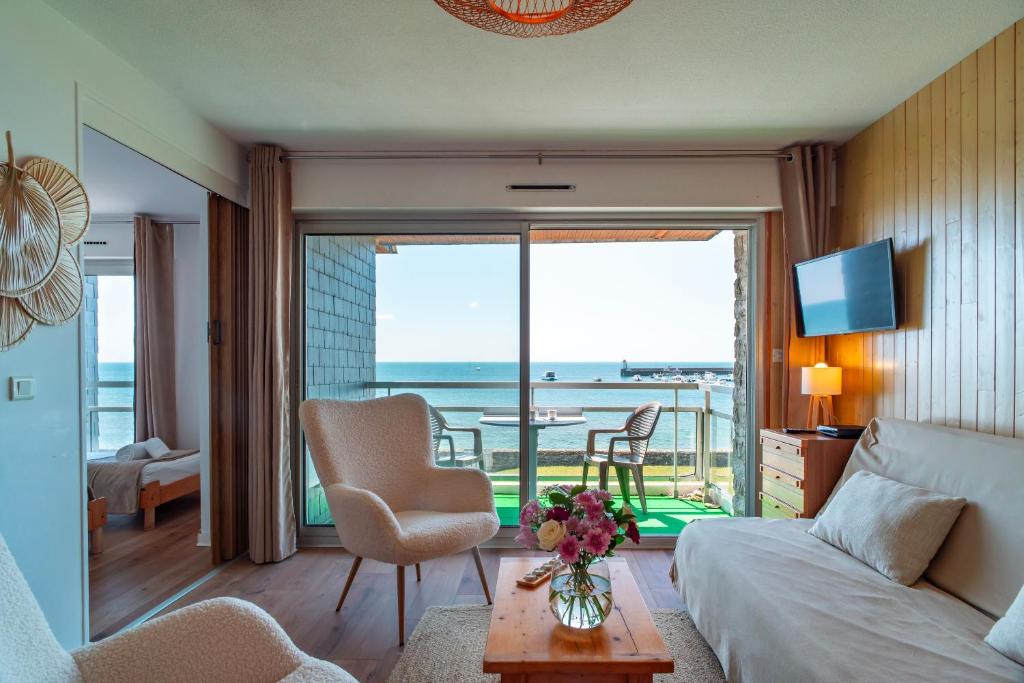 a living room with a bed and a view of the ocean at Le Mayalou - Vue Mer in Sarzeau