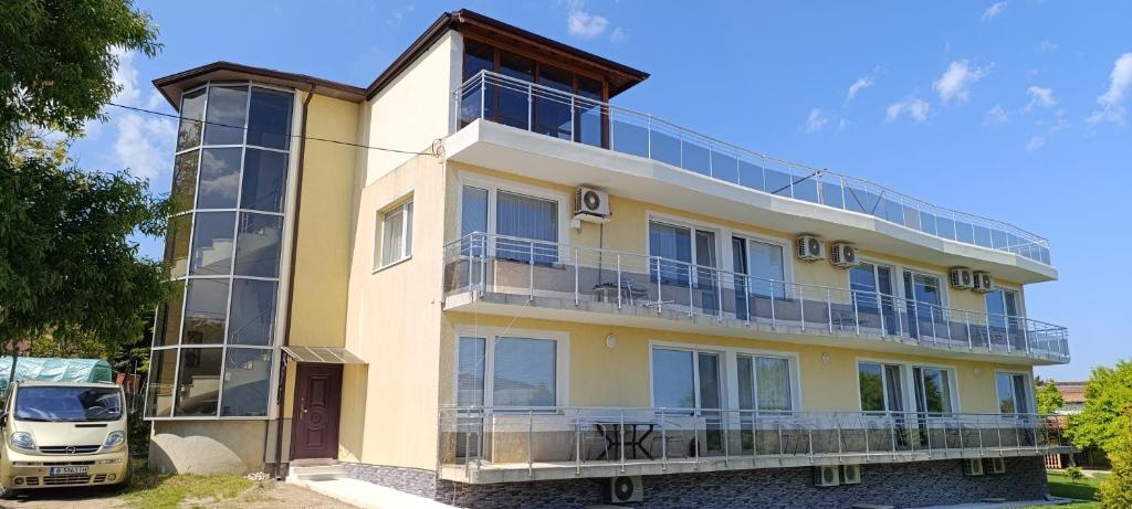 un edificio con balconi e un camion parcheggiato di fronte ad esso di Къща за гости ,,Лозница ГТ'' a Varna