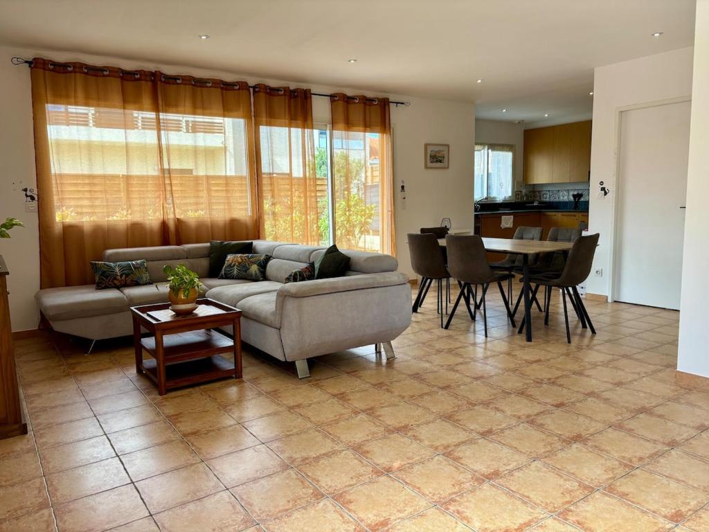 un soggiorno con un divano e un tavolo di Belle Maison Cosy et lumineuse a Canohès