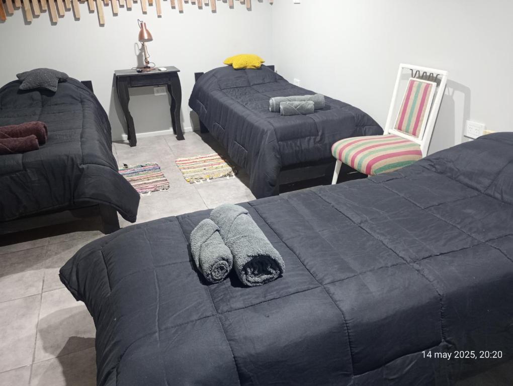 a bedroom with two beds and a couch and a chair at Alojamiento el descanso in Ezeiza