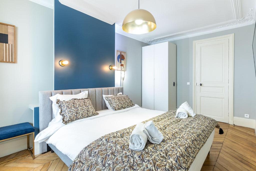 une chambre avec un grand lit avec des serviettes dessus dans l'établissement COSY APPARTMENT IN THE HEART OF PARIS, à Paris