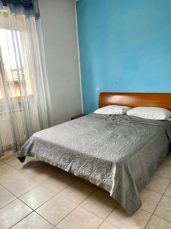 a bed in a bedroom with a blue wall at Appartamento 550 mt dal mare in Punta Marina