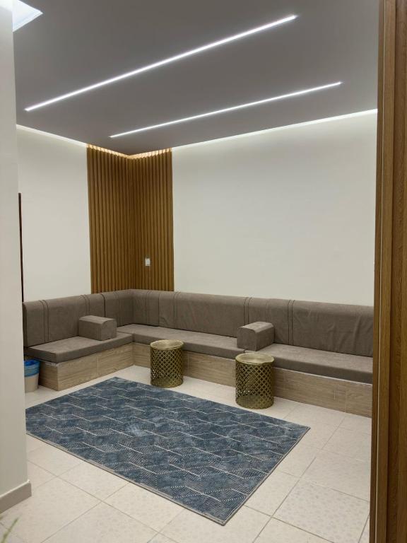 a waiting room with a couch and two stools at مساكن المدينة المنورة in Medina