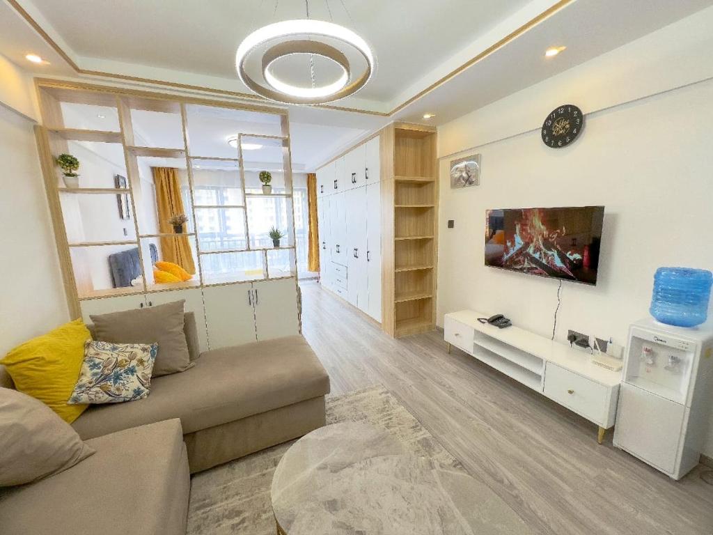 ein Wohnzimmer mit Sofa und Fernseher in der Unterkunft Kev Staycations in Nairobi