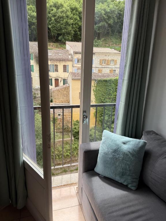 - un canapé en face d'une fenêtre avec vue dans l'établissement Rennes-les-Bains Studio at foot of thermal baths, à Rennes-les-Bains