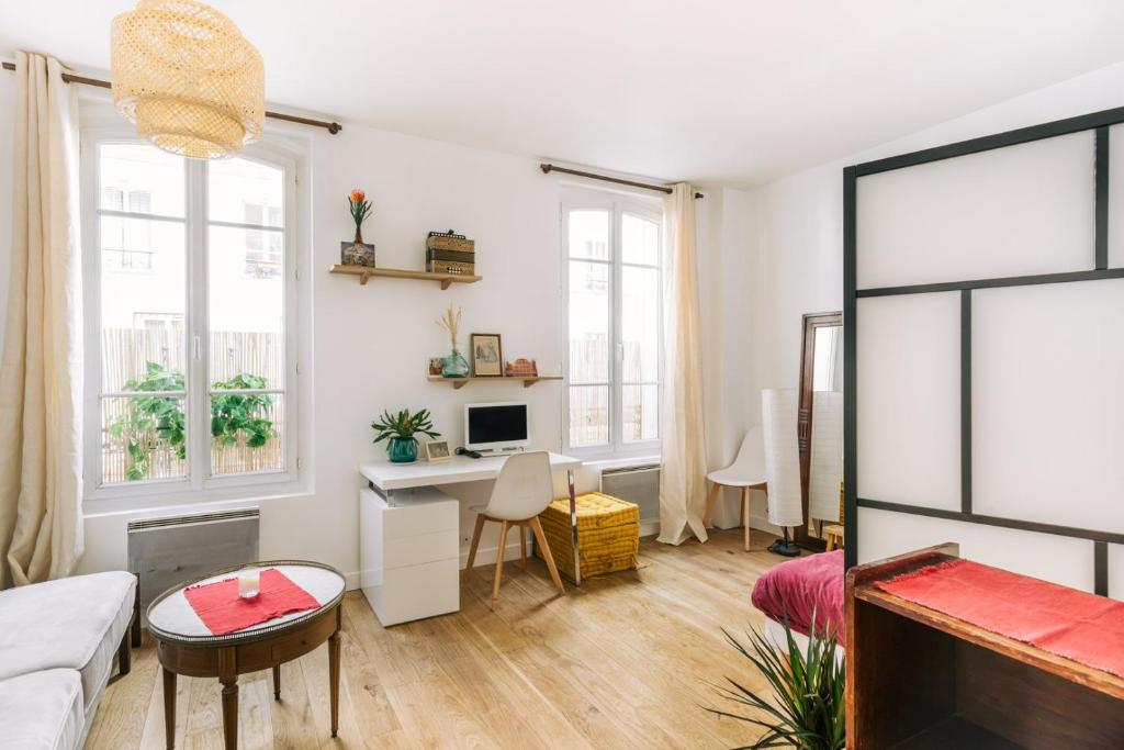 un salon avec un canapé et un bureau dans l'établissement GuestReady - Stylish comfort near Montsouris, à Paris