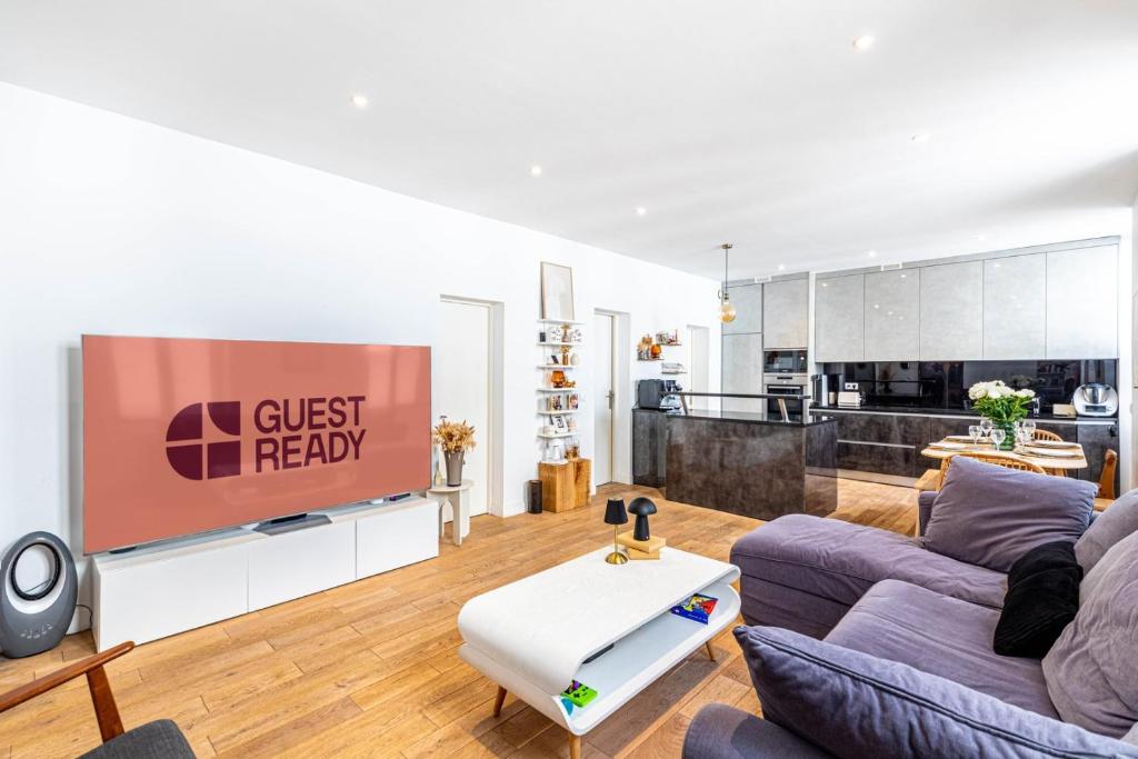 un salon avec un canapé et une télévision dans l'établissement GuestReady - Elegant retreat near the Eiffel Tower, à Paris