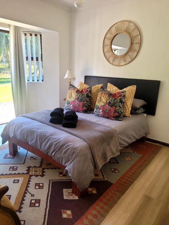 a large bed in a room with a mirror at River Front in Stellenbosch