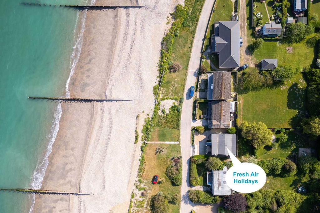 an overhead view of a beach with a sign that reads fresh air holidays at Historic Railway Home - Selsey Seafront in Selsey