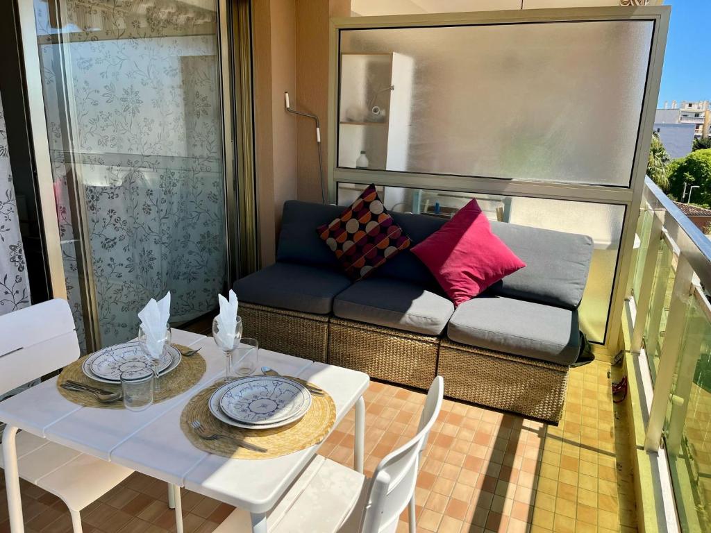 un balcon avec un canapé, une table et des chaises dans l'établissement Les CAMELIAS, à Antibes