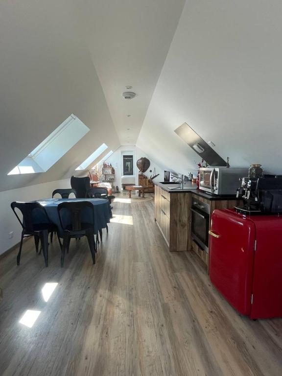 Il comprend une cuisine et une salle à manger avec une table et un réfrigérateur rouge. dans l'établissement Le repaire des trois singes, à Brésilley