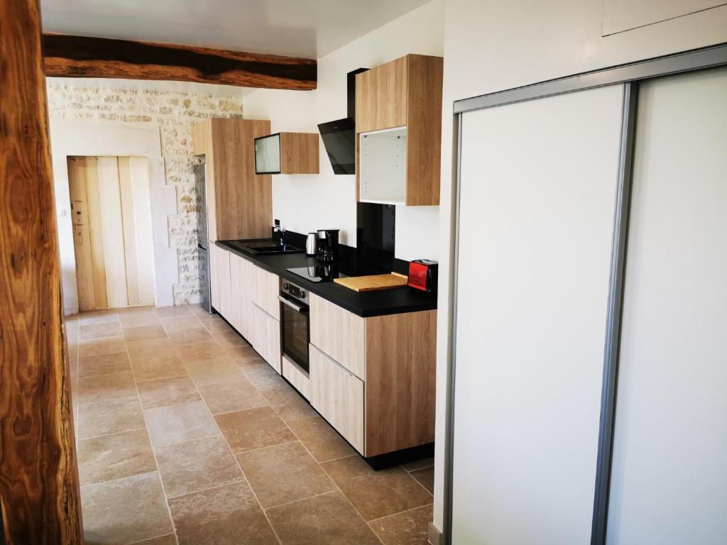 a kitchen with wooden cabinets and a counter top at La Maison d'Hortense au coeur du vignoble in Saint-Bris-le-Vineux