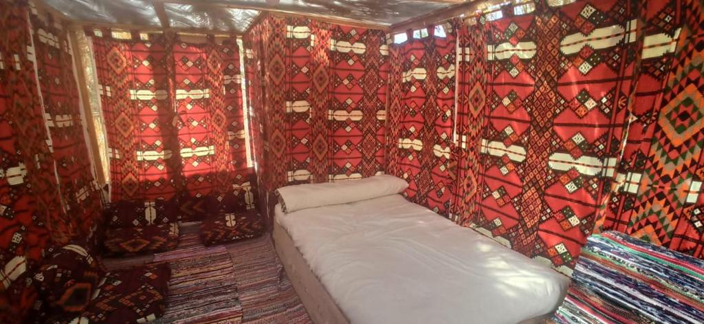 ein kleines Zimmer mit einem weißen Sofa in einem Zimmer mit Vorhängen in der Unterkunft Siwa Gardenia Cottage اكواخ سيوة جاردينيا in Siwa