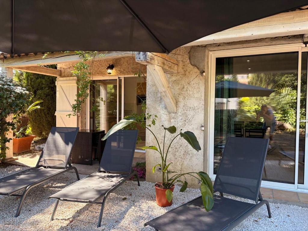 2 chaises assises sur une terrasse sous un parasol dans l'établissement Fabuleux T3 avec grand jardin - Sainte-Maxime, à Sainte-Maxime