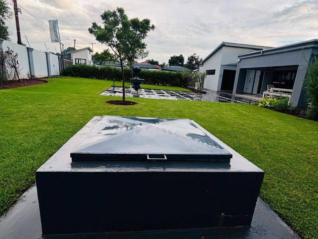 a laptop sitting on a table in a yard at Pula Nala Lodge in Rustenburg