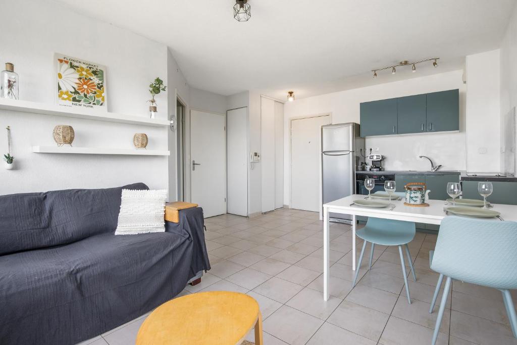 un salon et une cuisine avec un canapé et une table dans l'établissement Pause à Agde - Avec terrasse, à Agde
