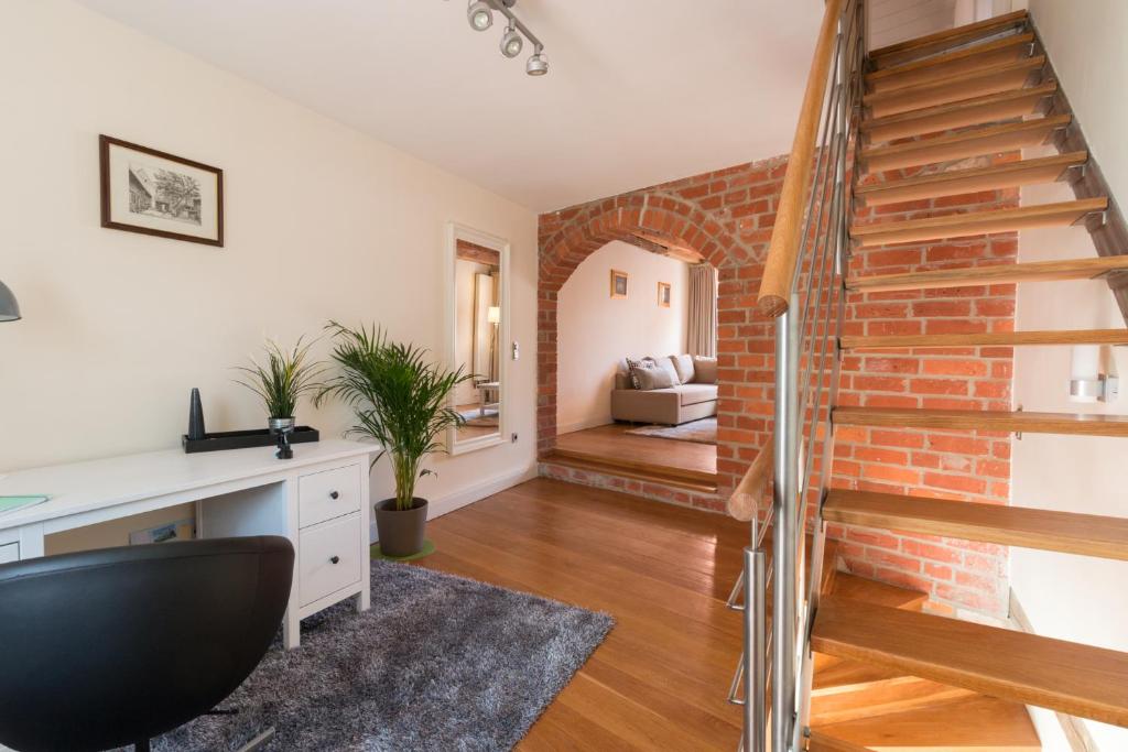 ein Wohnzimmer mit einer Treppe und einer Ziegelwand in der Unterkunft Altstadthaus "Schlägertwiete Nr.3" in Lüneburg