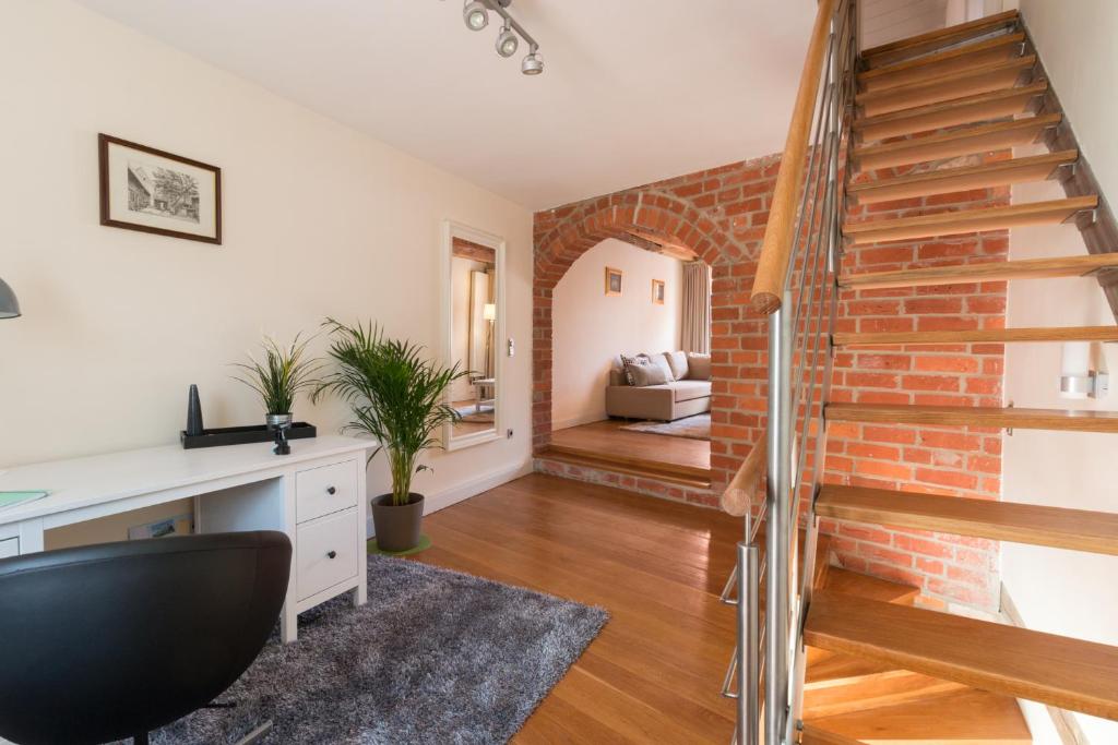 a living room with a staircase and a brick wall at Altstadthaus "Schlägertwiete Nr.3" in Lüneburg
