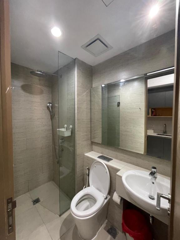 a bathroom with a toilet and a sink and a shower at Cozy Apartment connected to mall by Lexington in Jakarta