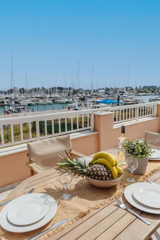 a table with a bowl of fruit on a balcony with a harbor at Christina's apartment 2 in Kontokali