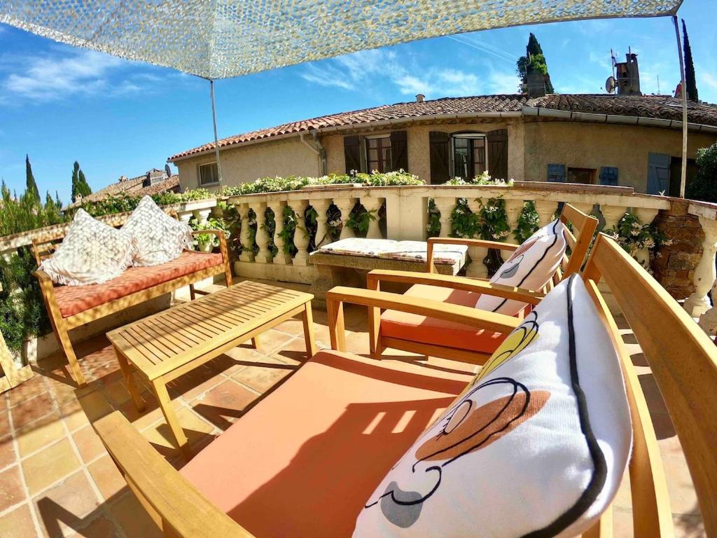 un patio avec deux chaises et un parasol dans l'établissement Maison de hameau au coeur de la campagne Grimaudoise, à Grimaud