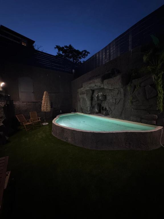 a hot tub in a yard at night at Casa Calipso in Catania